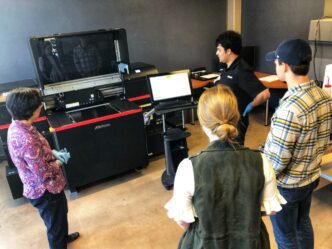 Clemson faculty gather around the 3D printer for training