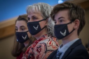 A young girl and boy and their mother with "Air Force" face masks