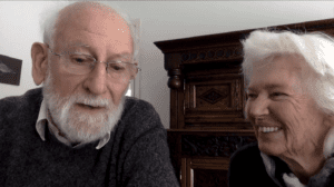 woman with gray hair looks at man with gray mustache and beard
