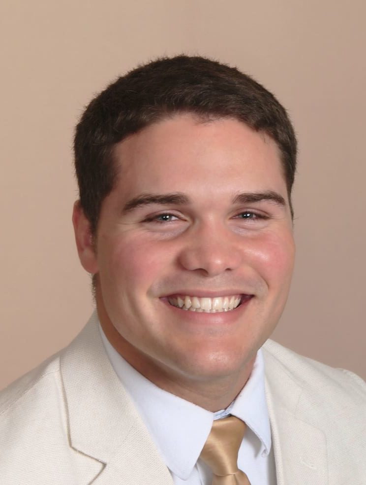 NSF Fellowship recipient wearing a suit and tie and smiling.