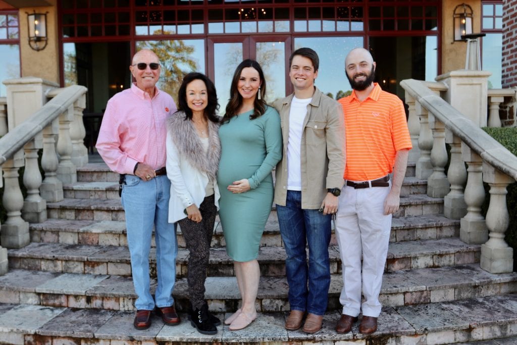 An outdoor portrait of the Glenn family standing on steps outside a home.