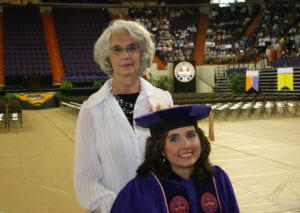 Alexander appears in her regalia and her mom is standing behind her and pushing her wheelchair. They paused for a photo.