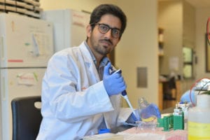 man wearing white lab coat in lab