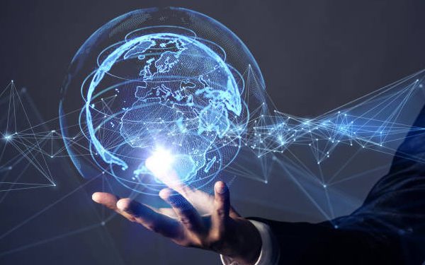 a virtual world or globe made up of technological lights being held in a person's hand