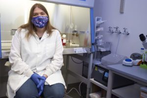 Jennie Mason sitting in front of some science lab equipment