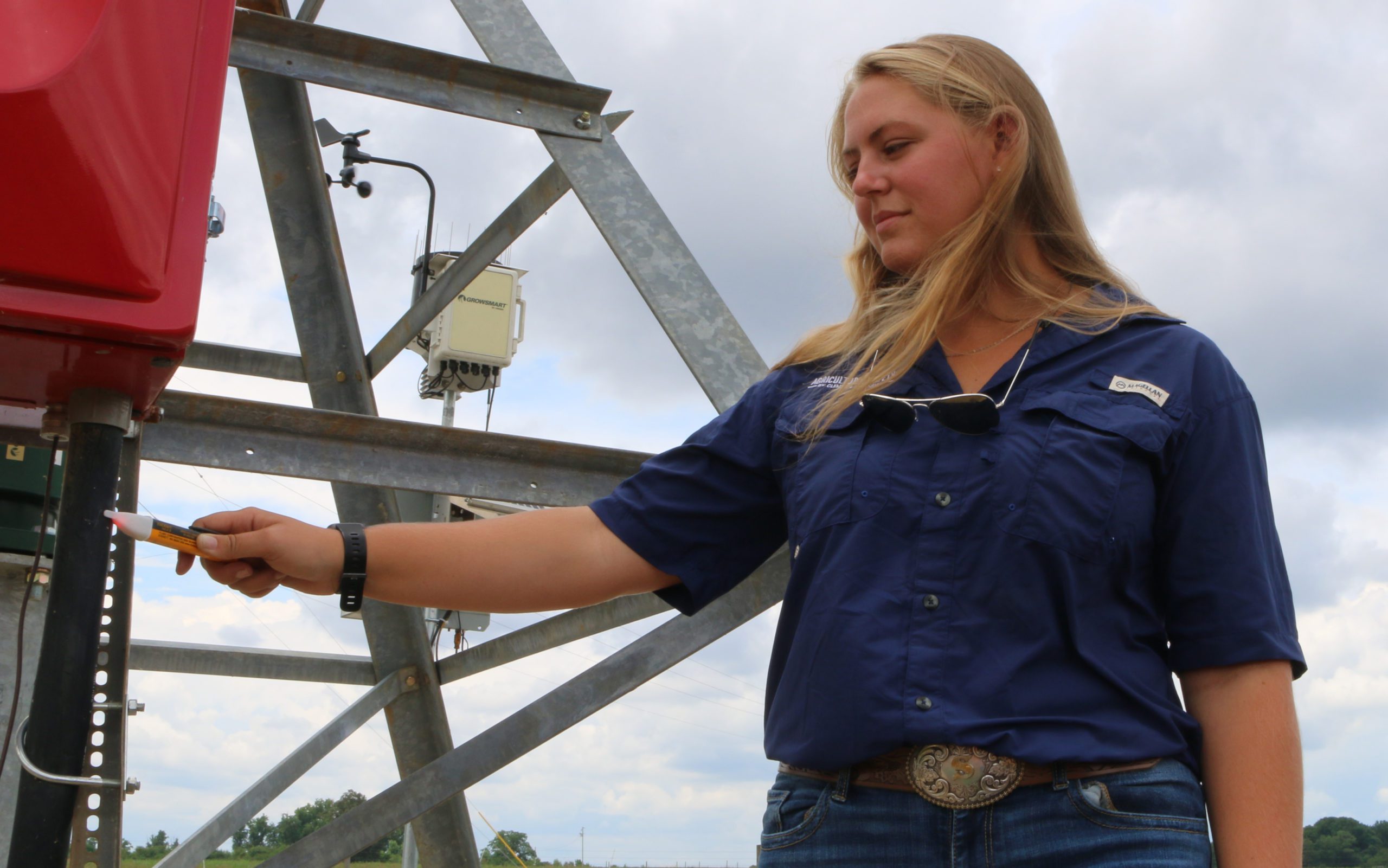 Shelley Lovern, Clemson master's student, tests a center pivot irrigation system at the Simpson REC with a voltmeter.