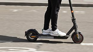 Person riding an electric scooter with blurred motion.