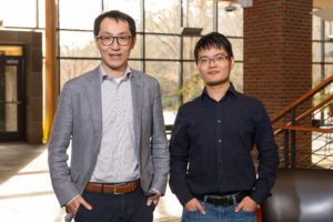 Two men standing next to each other posing for a photo.