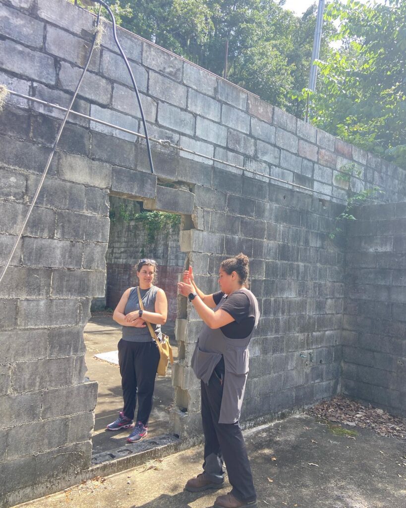 Jobie Hill speaks with student in the ruins of The Progressive Club on Johns Island.