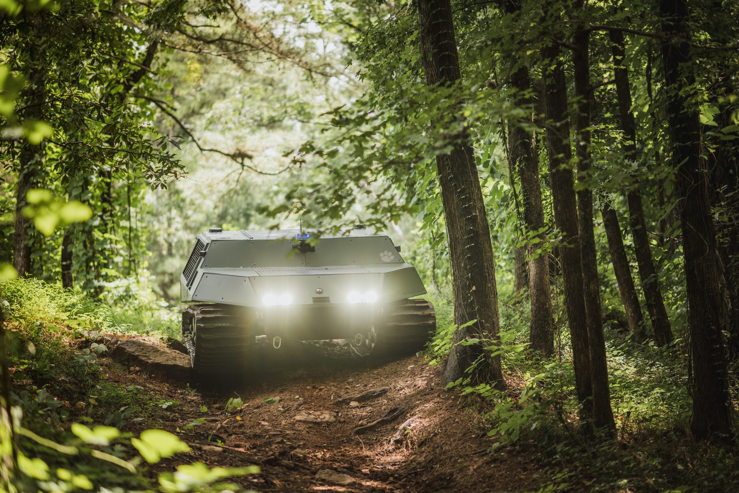 The Clemson University autonomous off-road vehicle, Deep Orange 14, tackles an obstacle-laden (rocks, uneven terrain, tree roots) dirt road in a forest.
