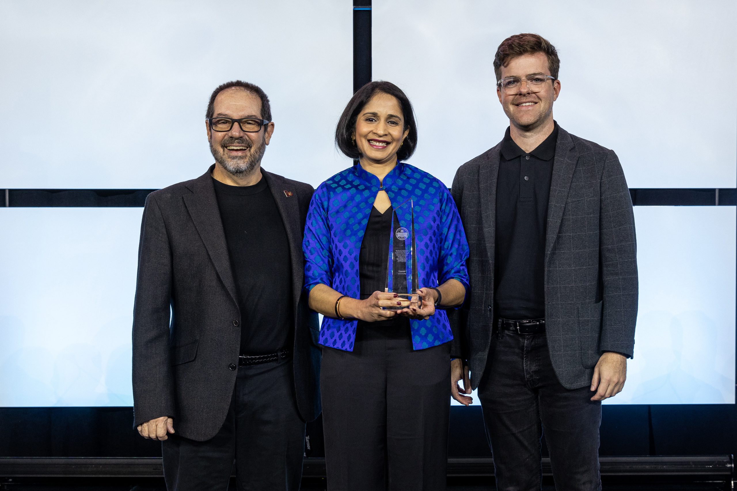 David Allison (left), Anjali Joseph (middle) and Austin Ferguson stand on stage at CHD accepting their Platinum Award.