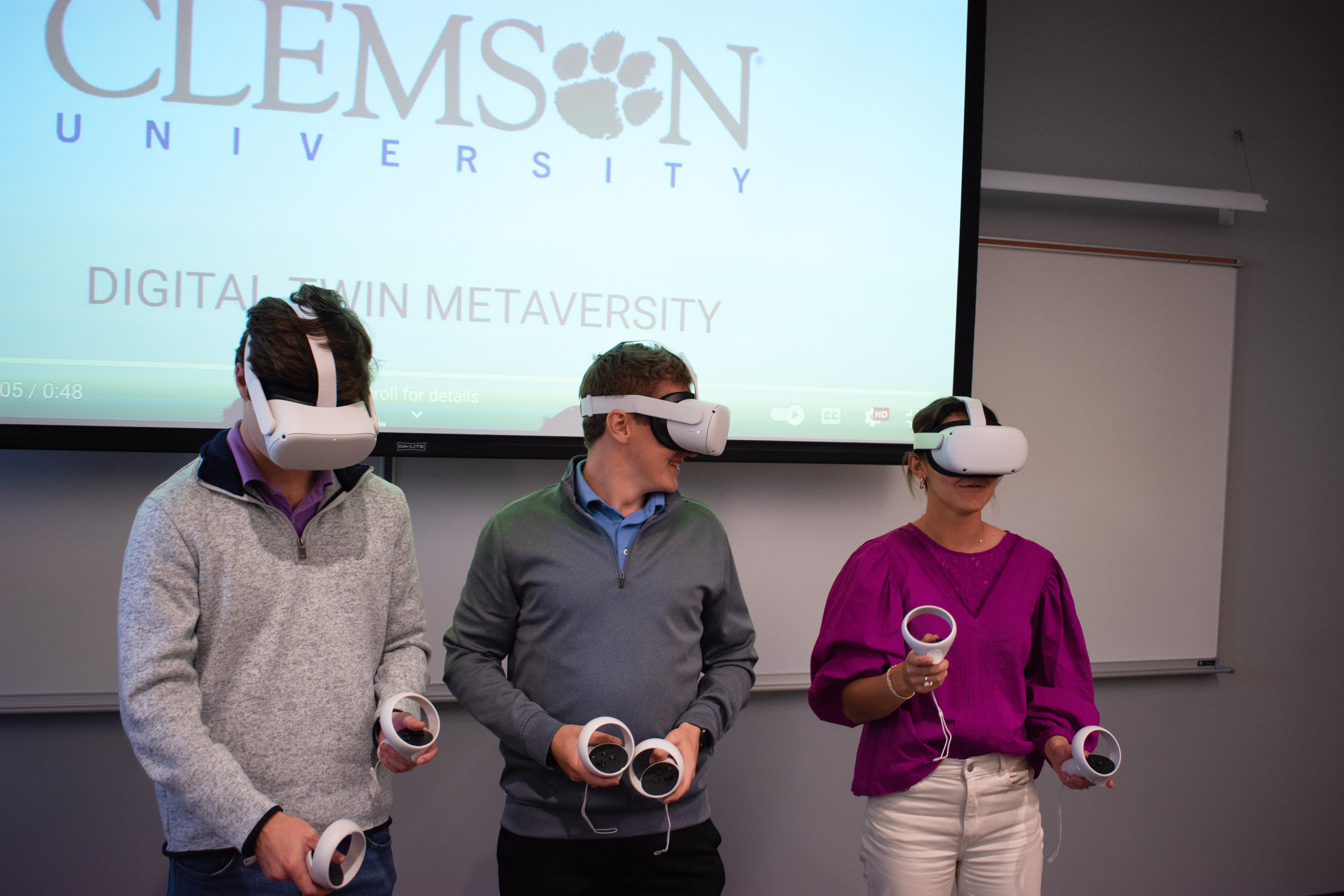 A group of 3 Clemson students using VR headsets in a class.