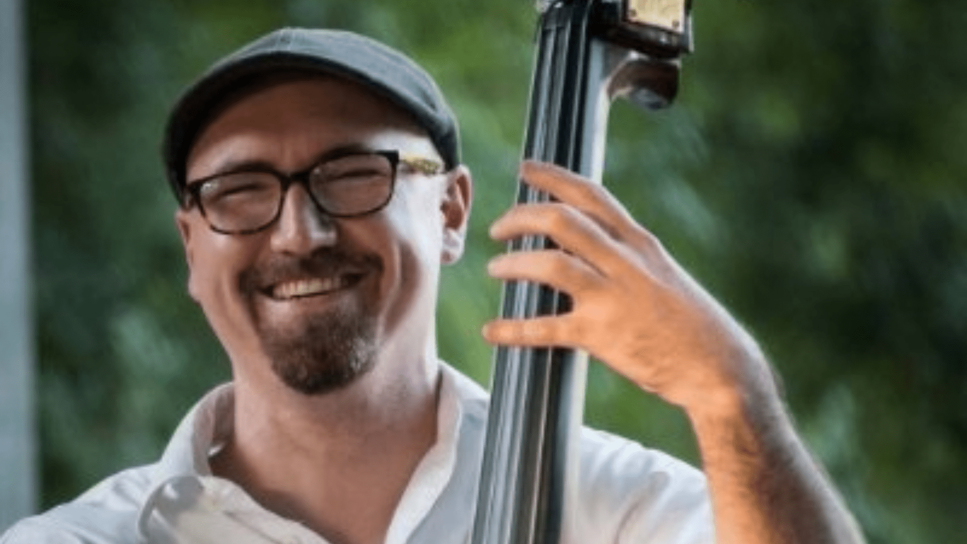 Michael Geib smiled at the camera as he plays his double bass.