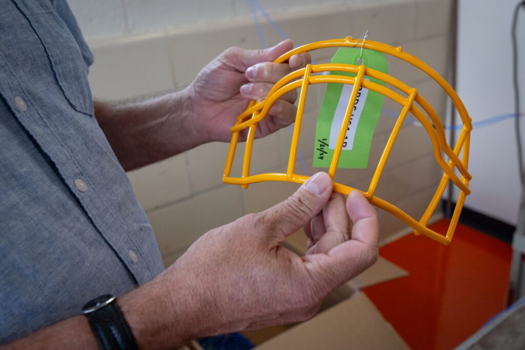 A man holds a test face mask in the lab.