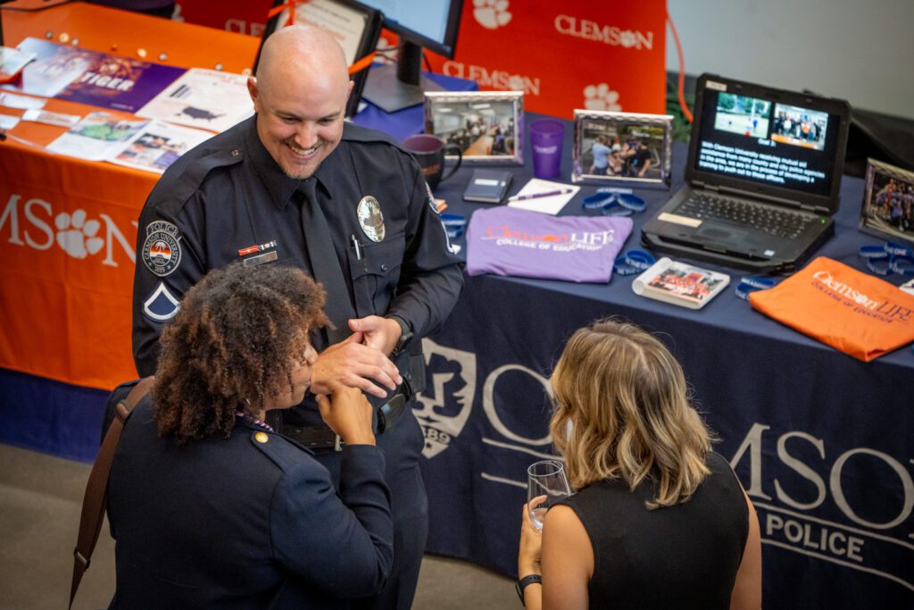 A man in a police uniform talks with two women.