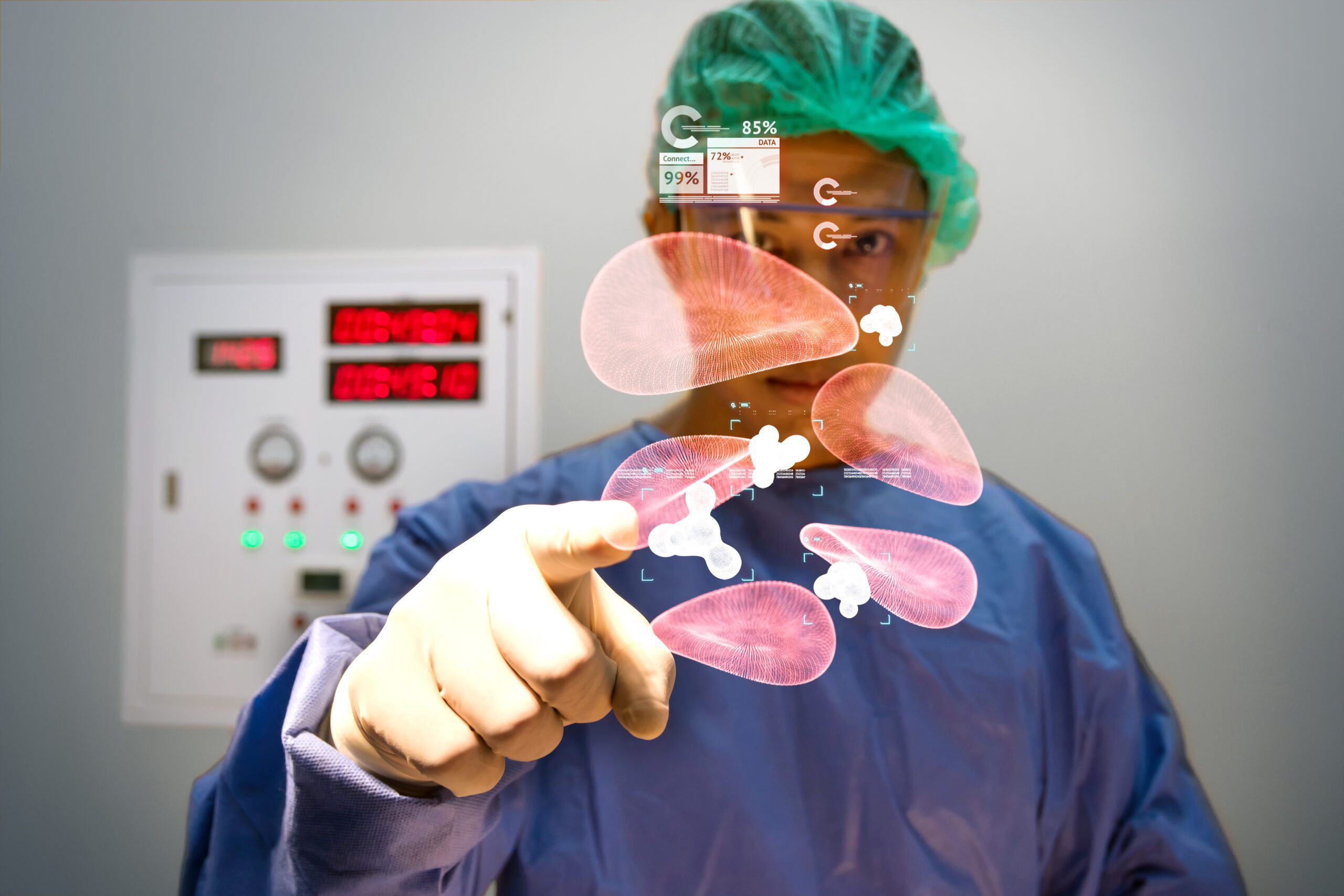 A male surgery doctor wearing blue scrubs and a green cap points finger see red blood cell hologram data from popup AR screen.