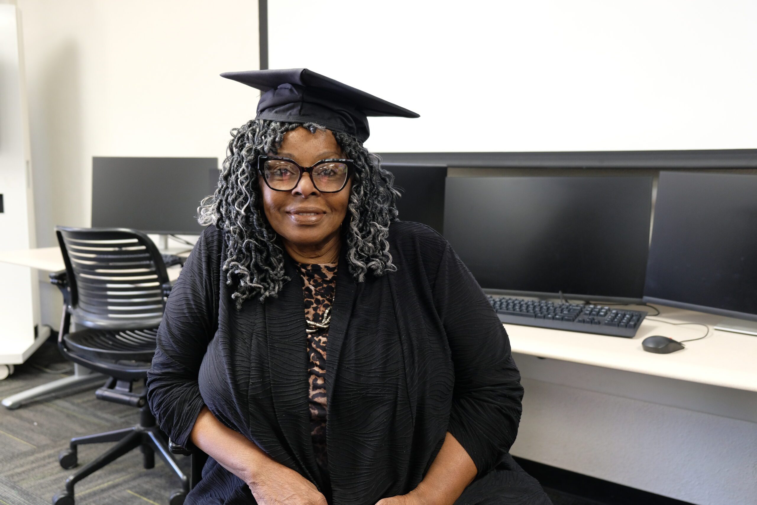 Darlene Williams Talbert smiles with a graduation cap to celebrate graduating GIS Fundamentals