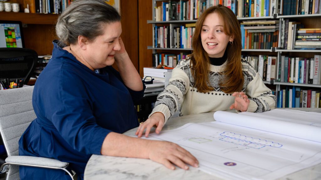 Two people look at an architectural drawing