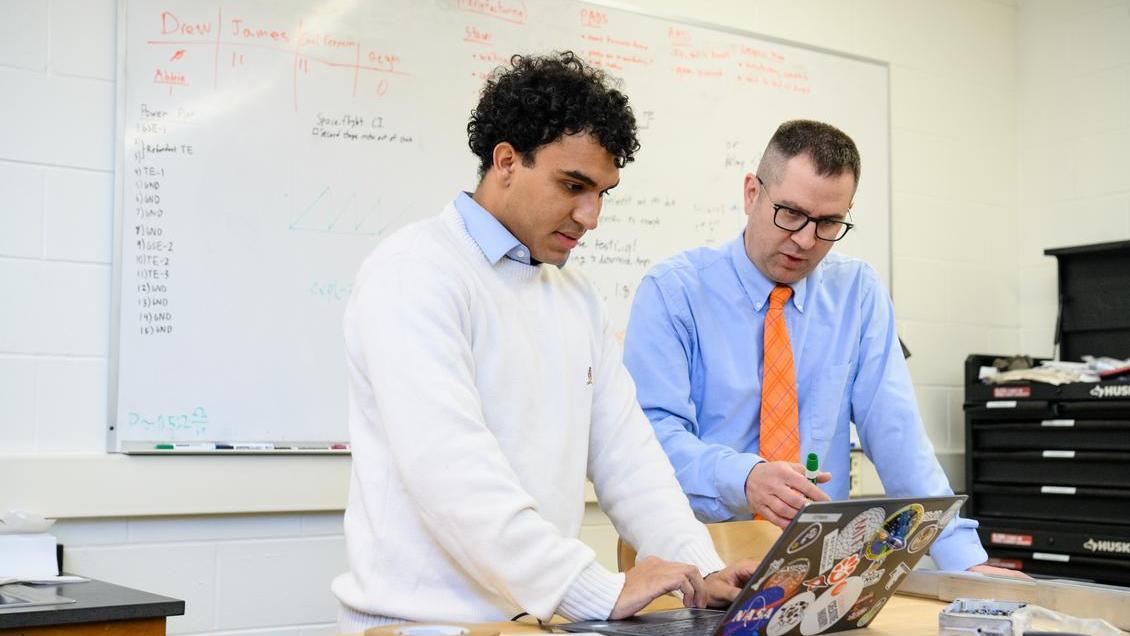 Fermin Redondo and Steve Kaeppler look at a laptop computer