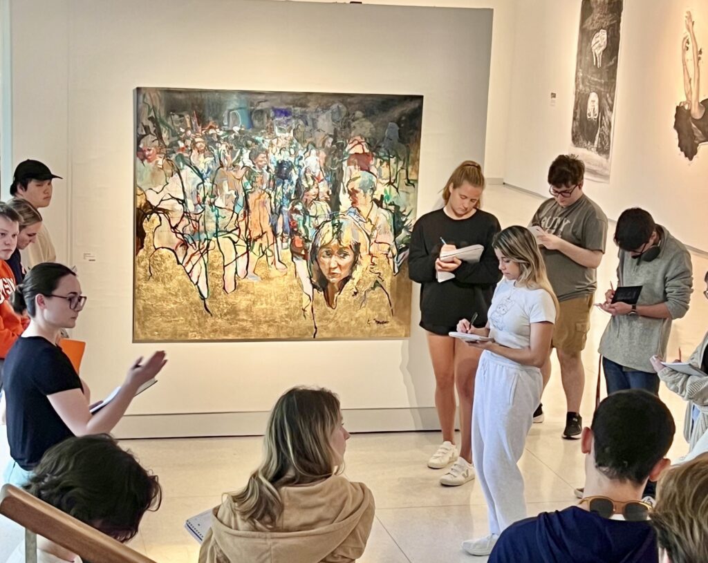 Art student Maya McDonald '25, co-curator of the Conversations exhibition, leads high school students in a discussion in the Lee Gallery.
