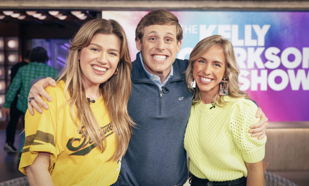 Tanner Smith stands with his arms around Kelly Clarkson on one side and his sister, Midge, on the other