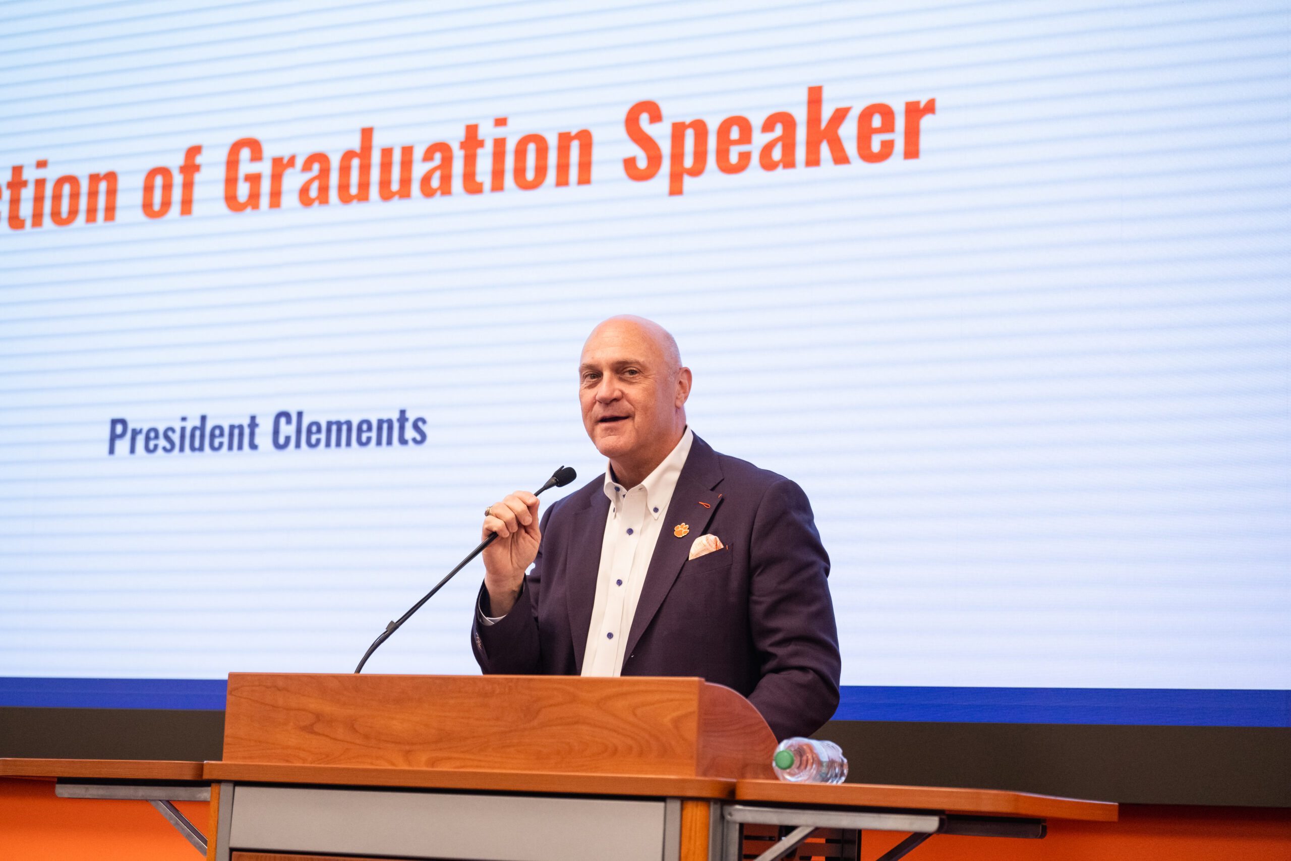 A person standing at a podium with a microphone.