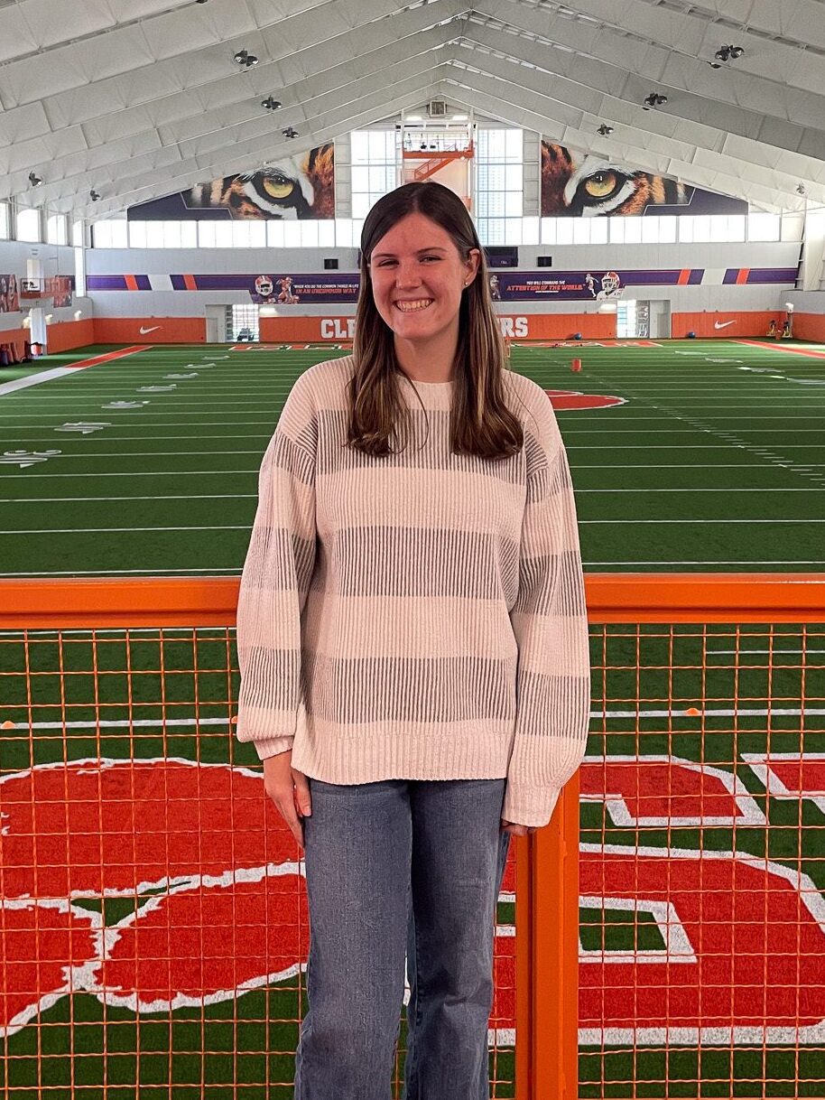 A woman standing at an indoor athletic facility, she is a Brooks scholar