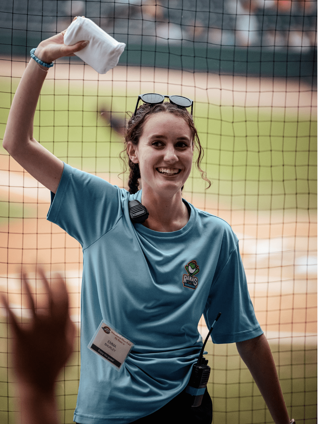 A woman holding an item over her head at a baseball field, she is a Brooks scholar