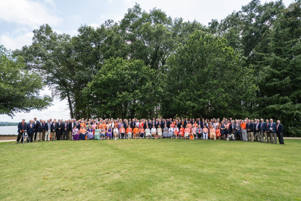 The Class of 1975 is shown gathered on a lawn with Lake Hartwell in the background.