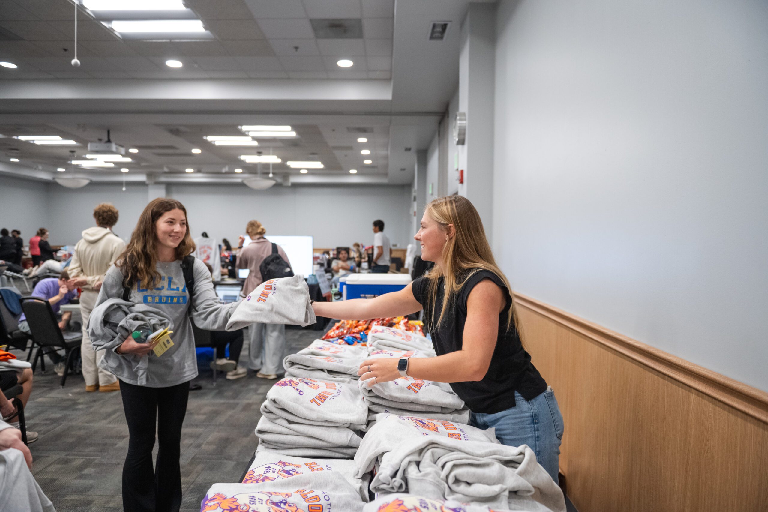 Lindsey Schmidt gives a t-shirt to a Blood Bowl donor in Fall 2024