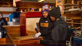 Two students work on a woodworking project.