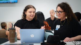 A student interacts with Clemson staff in the library