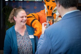 Rachel Anderson smiles for a photo with the Tiger mascot.