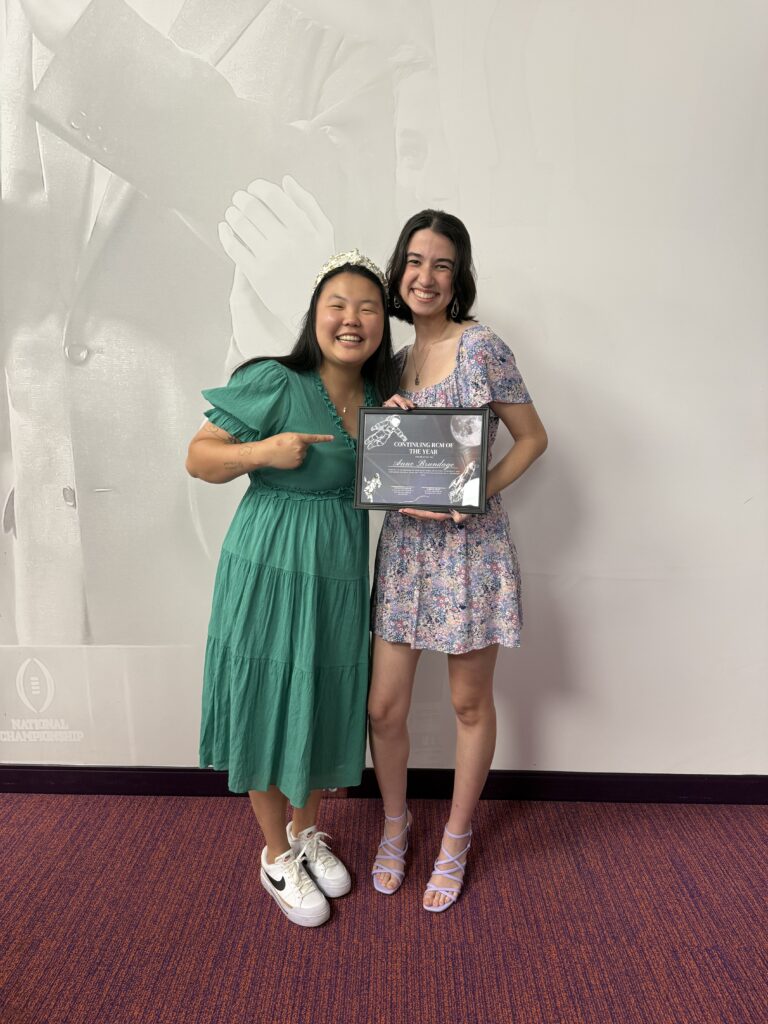 Skylar Walder congratulates Anne Brundage on earning an award for her work as a residential community mentor