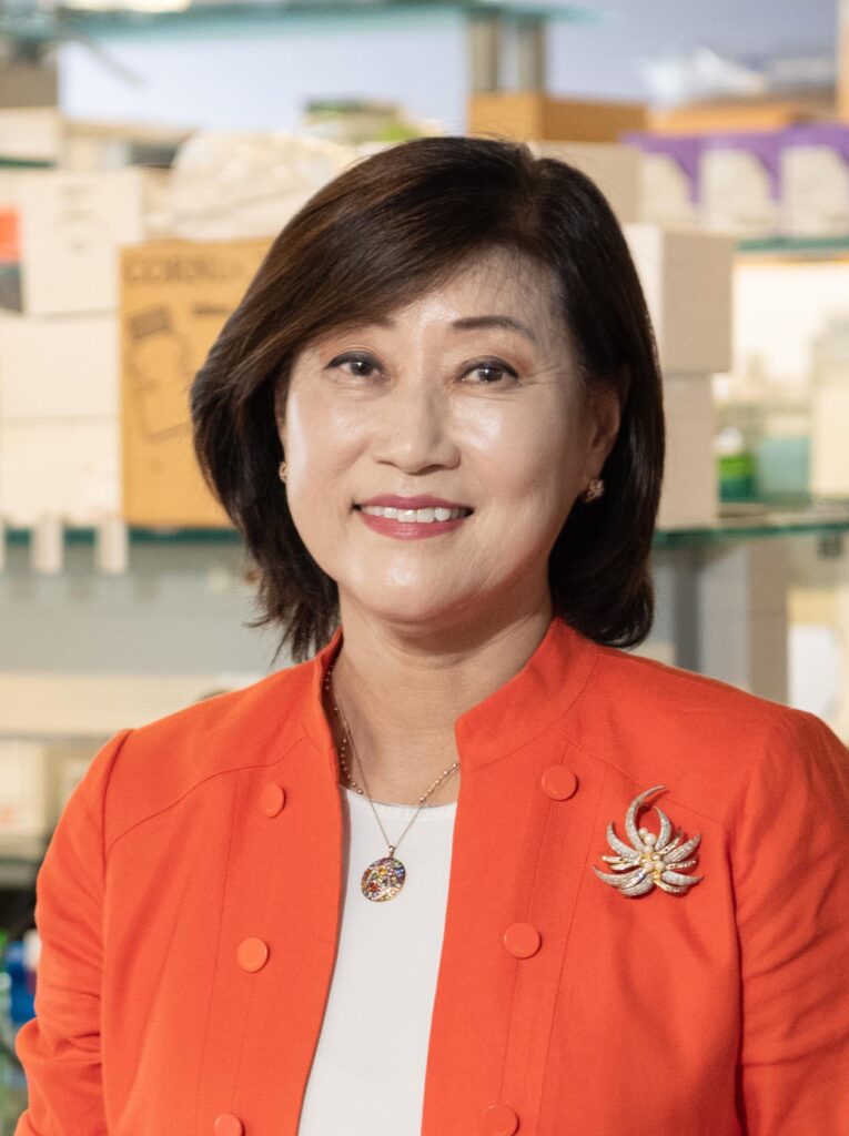 A woman wearing an orange blazer over a white shirt