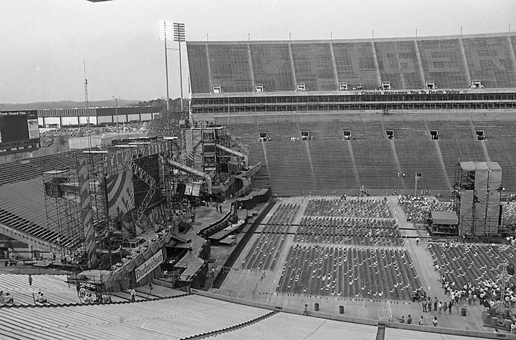 A view from the top bleachers of Memorial Stadium looking down on a huge stage being erected in the west end zone of Death Valley.